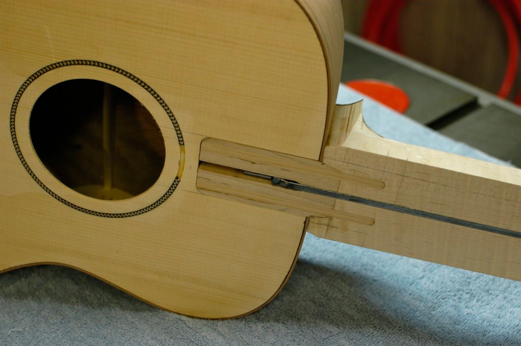 This style of neck joint adds support for the fingerboard along its entire length.