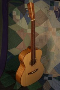 Orchestra guitar no 14 features red maple sides and back and an Adirondack spruce top.