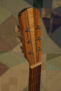 Orchestra guitar no 15 headstock front in palo escrito with a maple wedge.