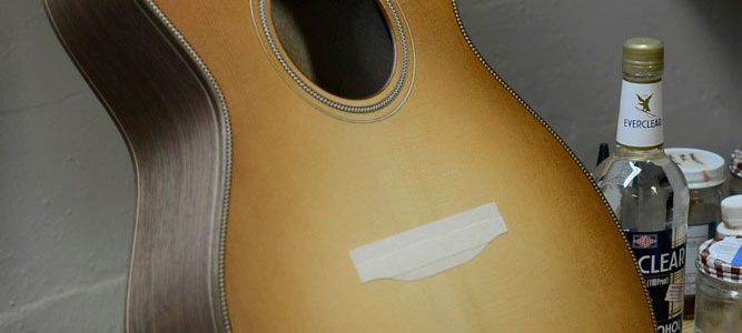 The first coat of shellac is applied over a sunburst dye job