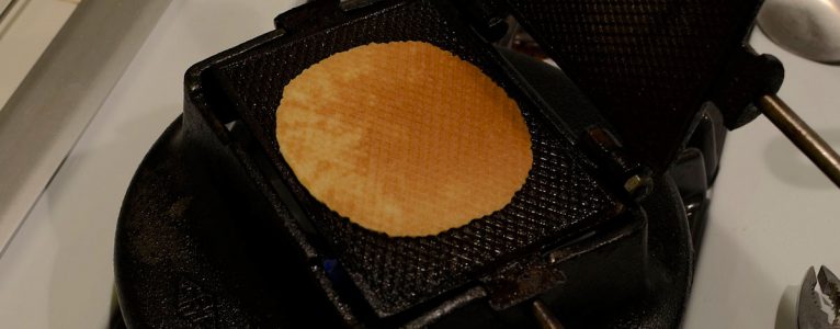An open lukken iron showing a baked cookie.