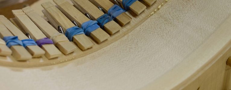 Linings being glued to a guitar rim.