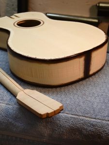 The hormigo binding has pores that need to be filled. I tape off the light areas of the instrument and apply pore filler to the hormigo only.