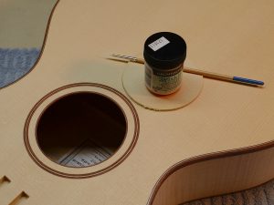 Before applying dye, I brush a coat of watercolor resist called Miskit liquid frisket on the wood bindings that I want to stay light in color.