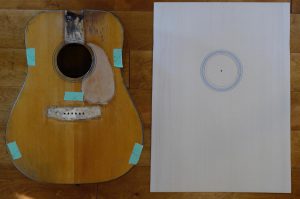 A new guitar top lying next to an old guitar body.