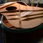 The top of a guitar, removed from the body.