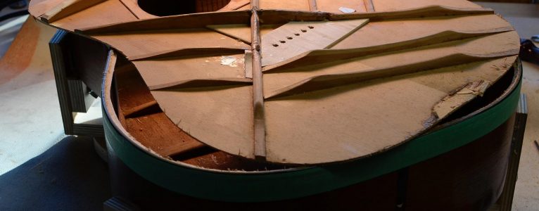 The top of a guitar, removed from the body.