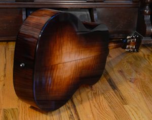 Showing the back side of a colored maple guitar body.