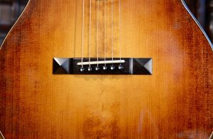 African blackwood bridge on a colored guitar top