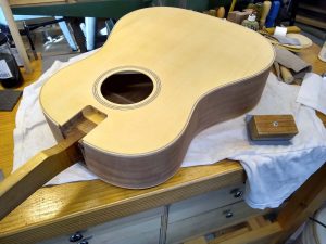 A guitar body with sanding tools.