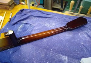 A guitar neck that has had finish applied